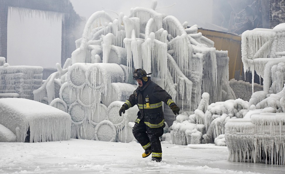 Chicago Fire Department Lieutenant De Jesus walks around an ice-covered warehouse that caught fire Tuesday night in Chicago