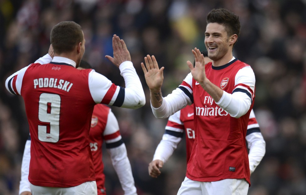 Arsenal's Giroud celebrates with teammate Podolski after Giroud scored a goal during their FA Cup fourth round soccer match against Brighton and Hove Albion in Brighton