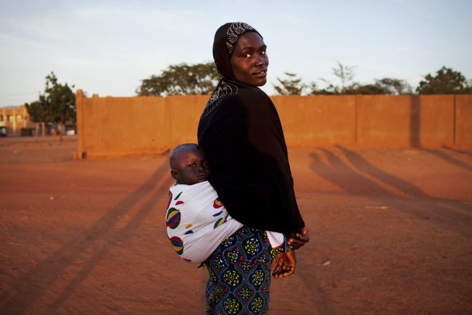 Douentza resident Kadjiatou poses for a picture with her child on her back in the recently liberated town