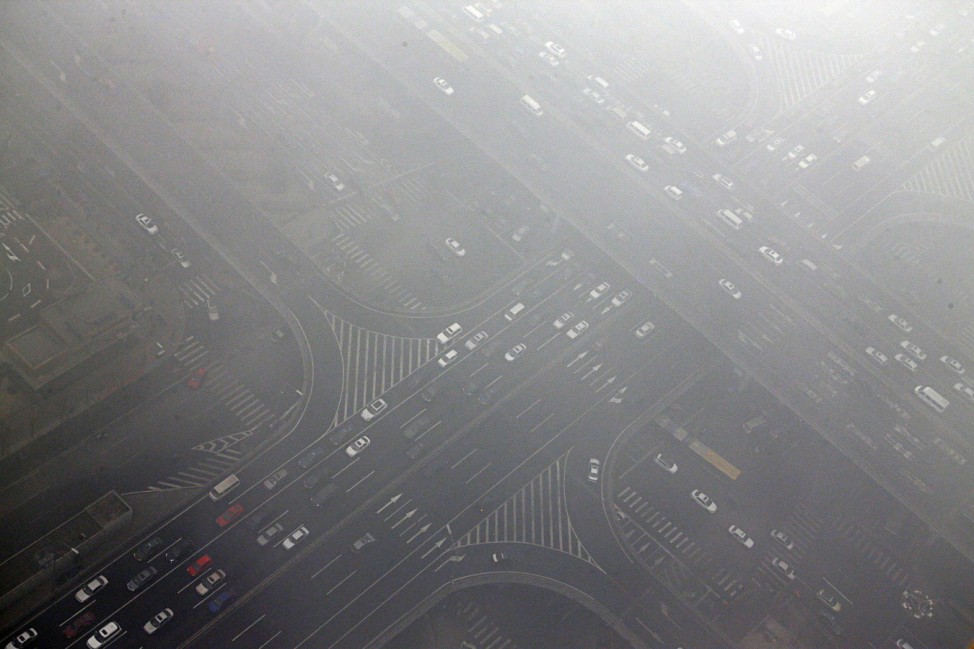 Cars drive through Guomao bridge on a heavy hazy day in Beijing's central business district