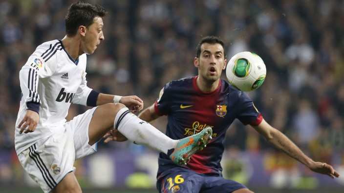 Real Madrid's Ozil fights for the ball with Barcelona's Busquets during their Spanish King's Cup semi final first leg soccer match in Madrid