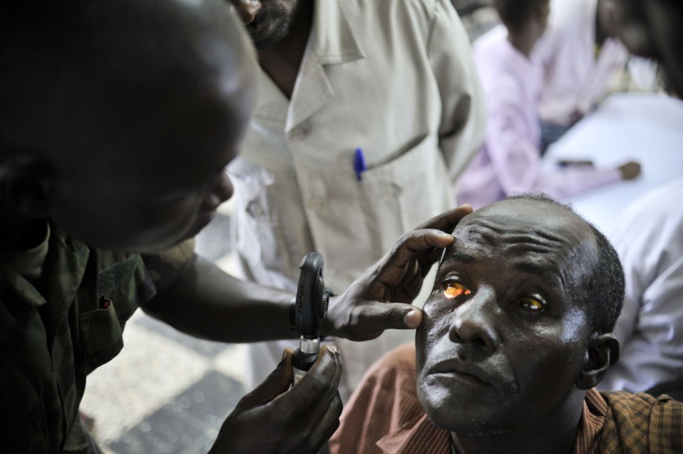 An army medic checks a patient's eyes at a medical outreach centre in Mogadishu