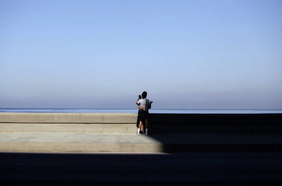 A couple stand on Havana's seafront boulevard 'El Malecon'
