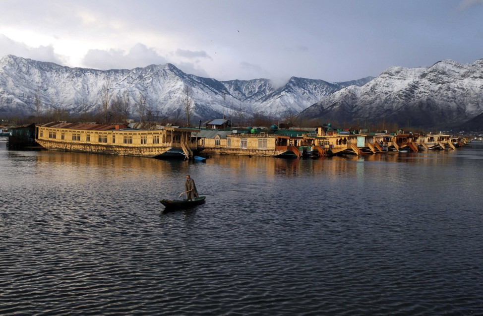 A Kashmiri man rows his boat in the waters of the Dal Lake on a cold winter evening in Srinagar