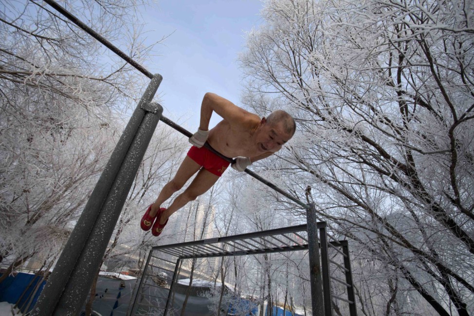 Gao Yinyu does his morning exercise before swimming in Songhua river in Jilin