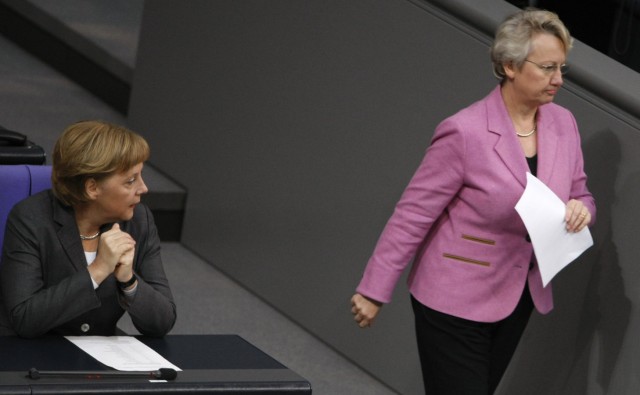 German Chancellor Merkel looks to German Education and Science Minister Schavan as she walks to podium in Bundestag in Berlin