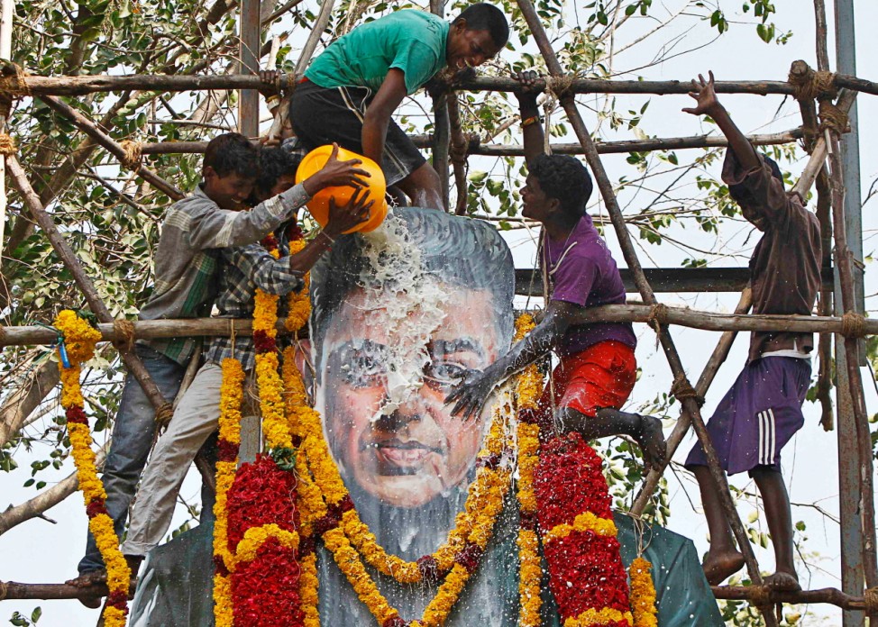 Fans of actor and director Haasan pour milk on his life-sized cardboard cut-out in Chennai