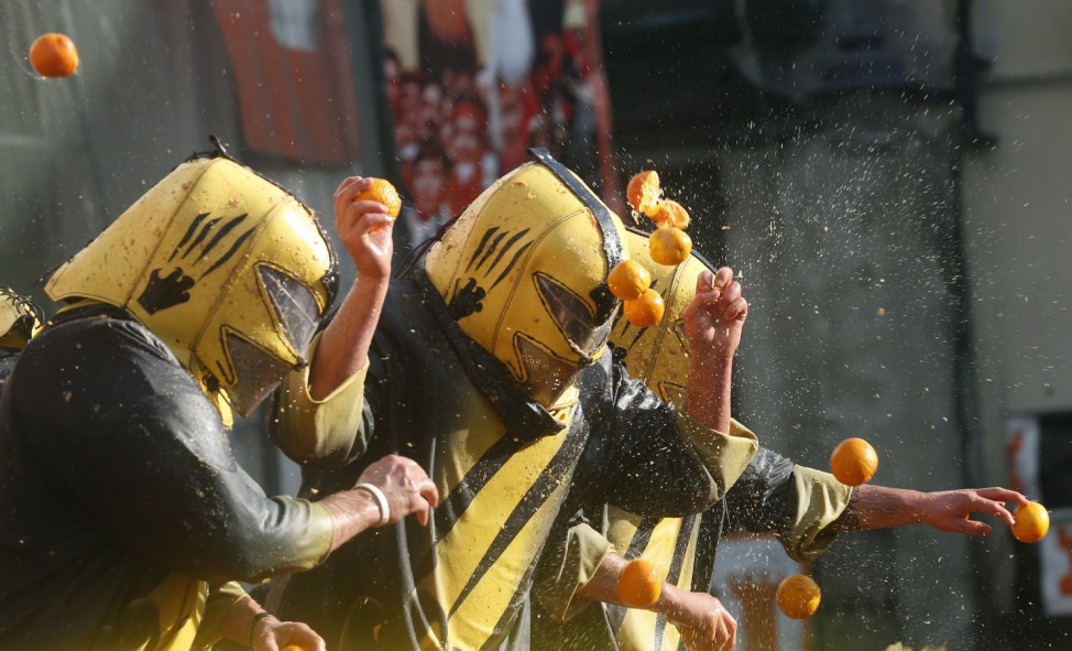 A member of a rival team is hit by oranges during an annual carnival battle in the northern Italian town of Ivrea