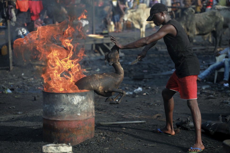 A man roasts a goat at the Swali slaughter site in Yenagoa, the capital city of Bayelsa, Nigeria's oil state located in the Delta region