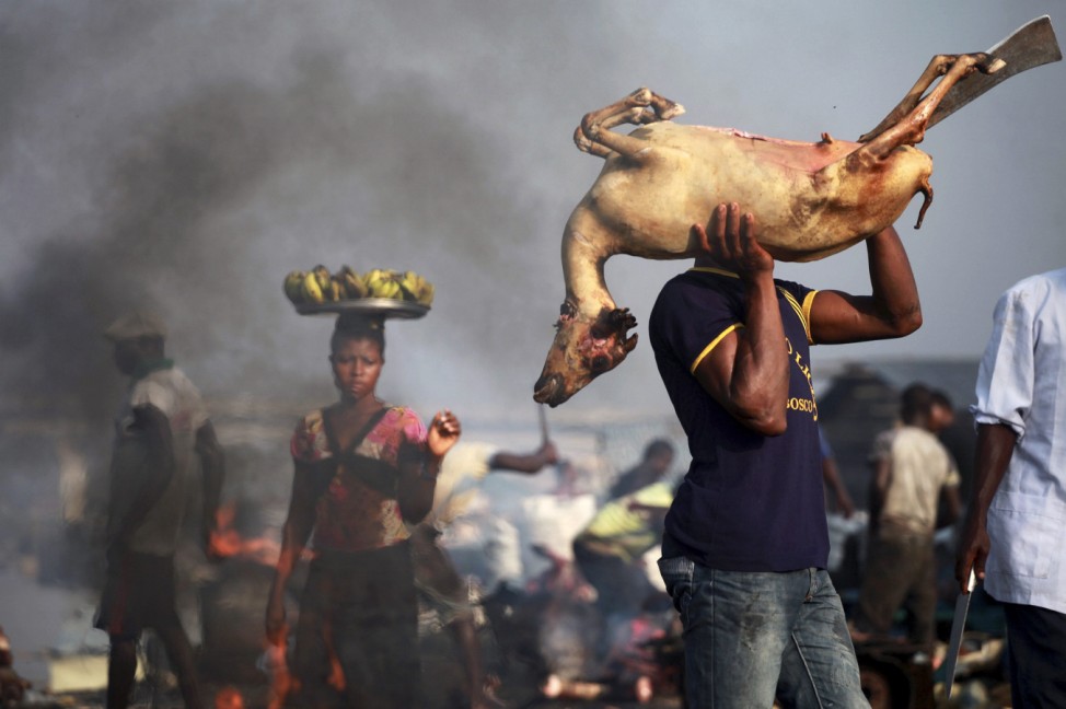 A man lifts a roasted goat on his shoulder through the Swali slaughter site in Yenagoa, the capital city of Nigeria's oil state of Bayelsa in the Delta region