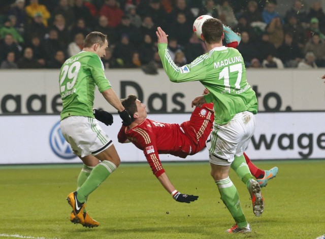 VfL Wolfsburg's Polak and team mate Madlung try to save as Bayern Munich's Mandzukic kicks ball during German Bundesliga first division soccer match in Wolfsburg