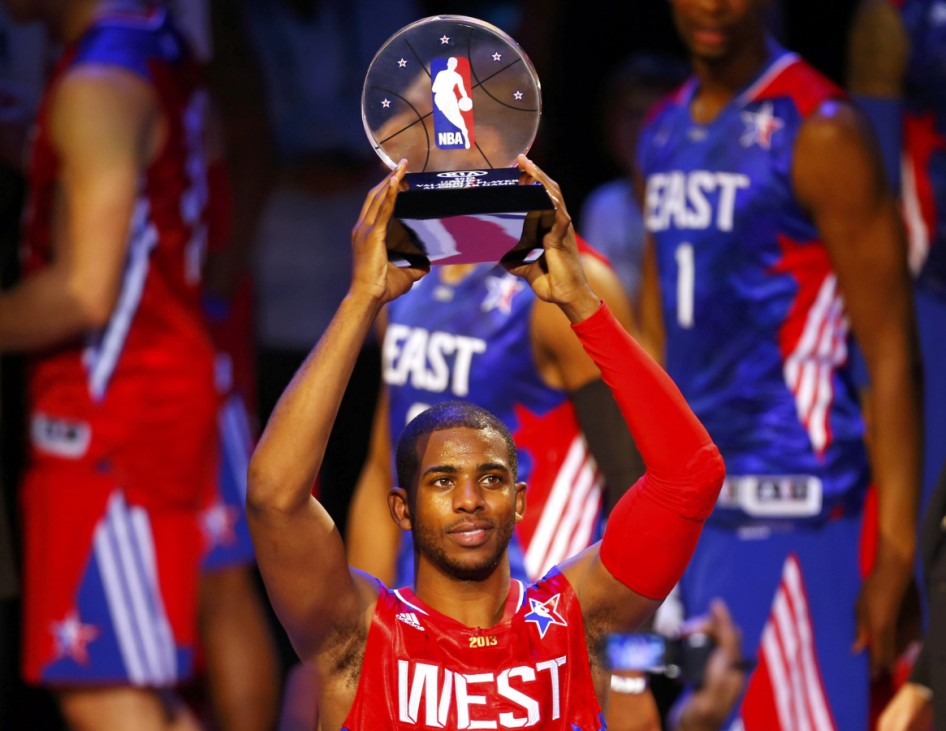 NBA All-Star Chris Paul of the Los Angeles Clippers holds up the MVP trophy after the 2013 NBA All-Star basketball game in Houston