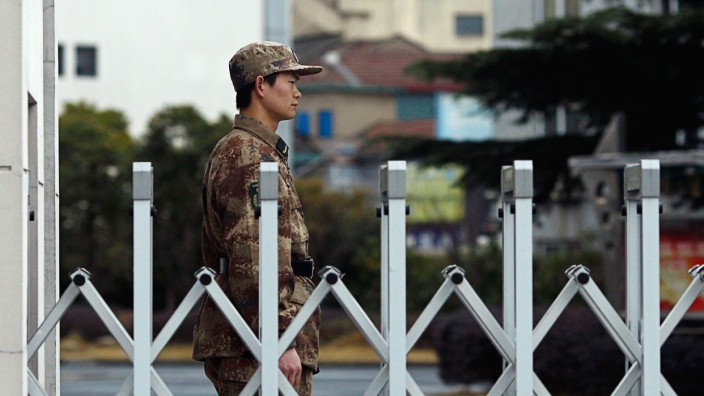 A Chinese People's Liberation Army soldier stands guard in front of 'Unit 61398' in the outskirts of Shanghai