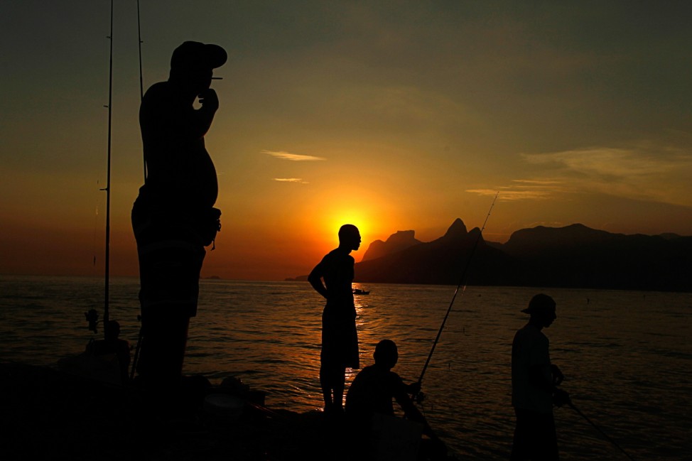 People fish on the rocks of Arpoador beach in Rio de Janeiro