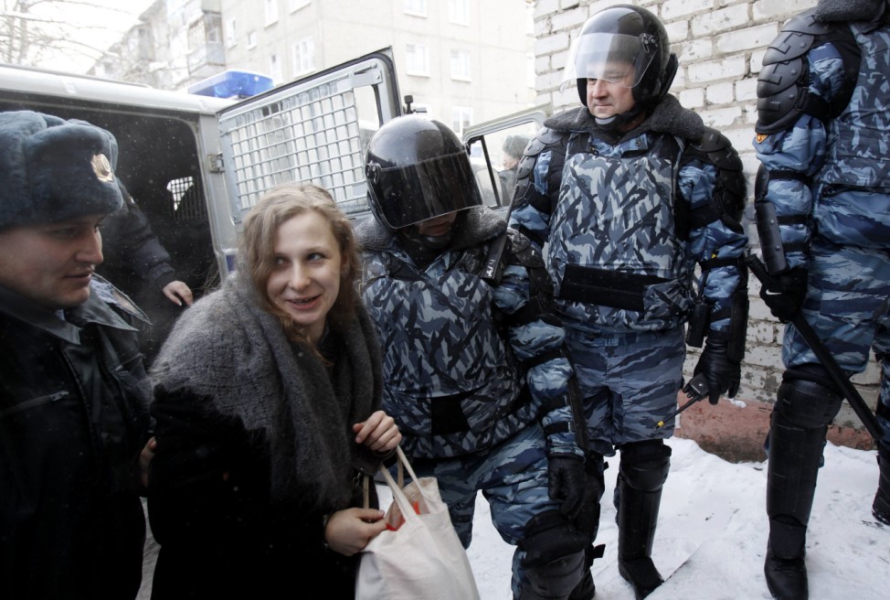 Alyokhina, a member of the female punk band 'Pussy Riot', is escorted before a court hearing in Berezniki