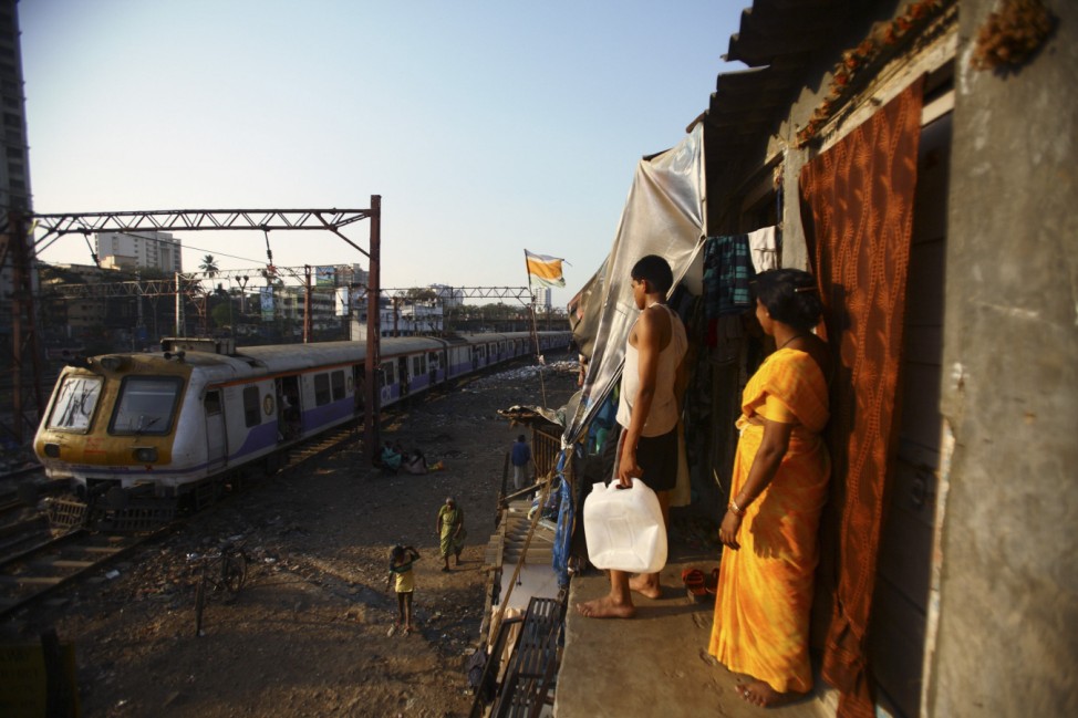 A train passes through slums in Mumbai