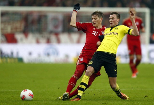 Bastian Schweinsteiger of Bayern Munich challenges Kevin Grosskreutz of Borussia Dortmund during their German soccer cup, DFB Pokal, quarter-final soccer match in Munich
