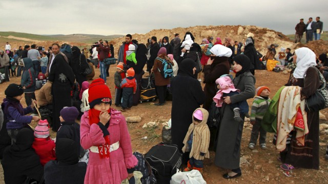Syrische Familien an der Grenze zu Jordanien. Die Aufnahme entstand nahe Mafraq am 18. Februar 2013. Syrien
