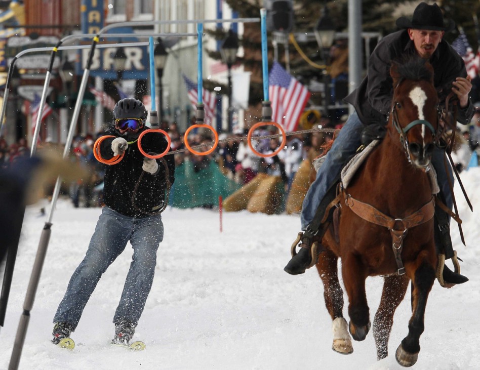 A horseman pulls a skier down the snow-covered main street during the annual skijoring race in downtown Leadville, Colorado