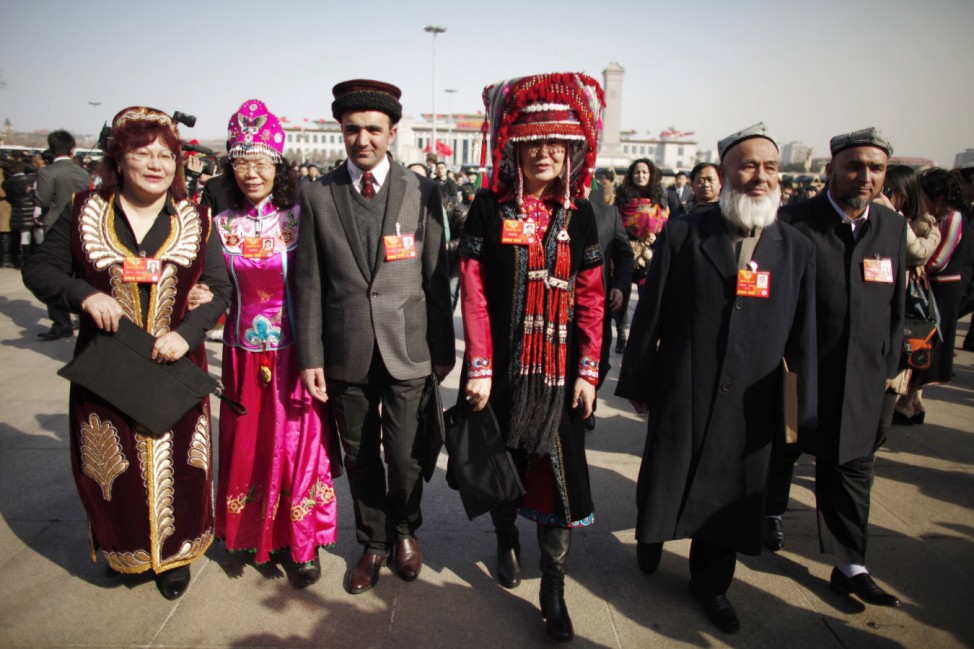 Ethnic minority delegates wearing traditional costumes walk towards the Great Hall of the People, ahead of the opening ceremony of the Chinese People's Political Consultative Conference in Beijing