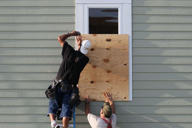 Männer präparieren ein Haus vor dem Hurrikan