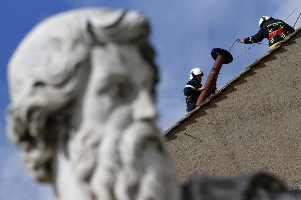 Members of the fire and rescue service set a chimney on the roof of the Sistine Chapel at the Vatican