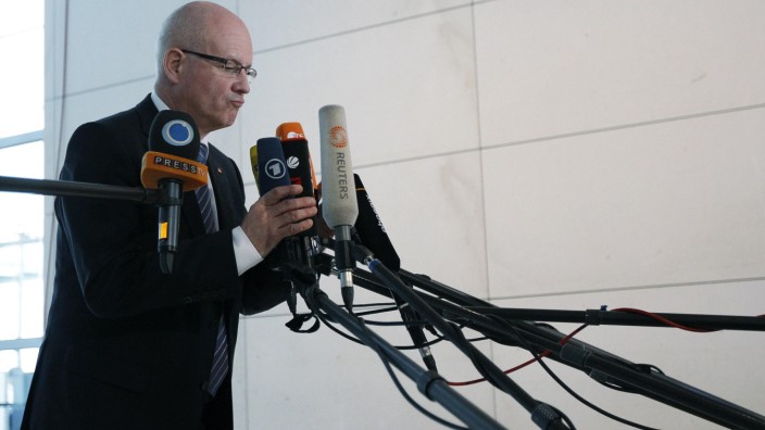 CDU parliamentary faction Kauder grabs reporters' microphones before giving interview on outcome of Bundestag vote on euro zone rescue fund in Berlin