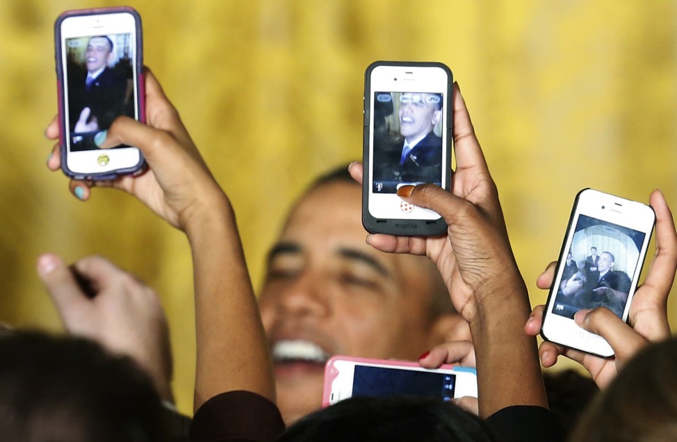 Attendees photograph U.S. President Obama with their phones at a Women's History Month reception in Washington