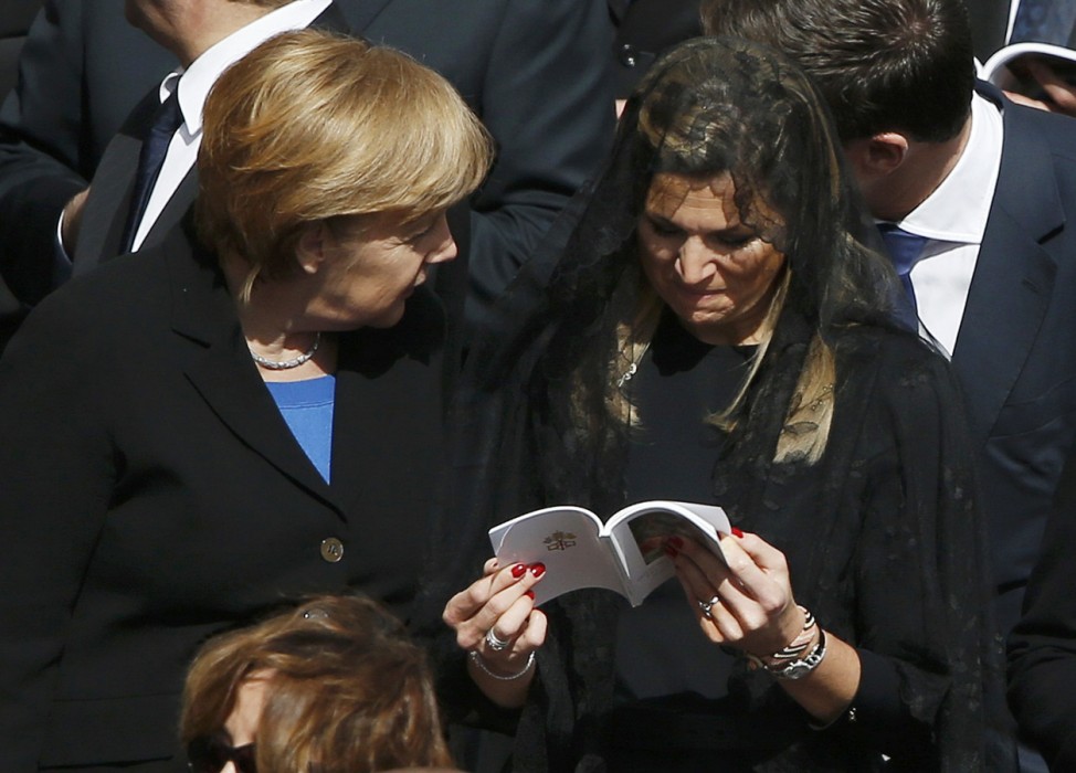Princess Maxima of the Netherlands speaks with Germany's Chancellor Angela Merkel as they attend the inaugural mass of Pope Francis at the Vatican