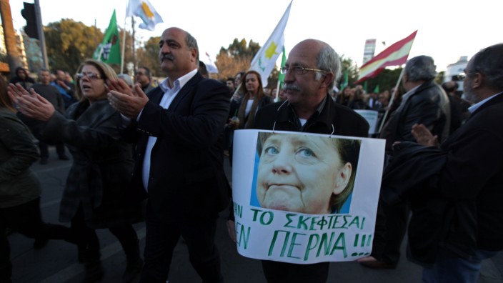 Finanzkrise in Zypern: Demo in Nikosia: Demonstrant mit einem Schild und Merkels Konterfei und dem Text "Denk gar nicht dran, ich weiche nicht"