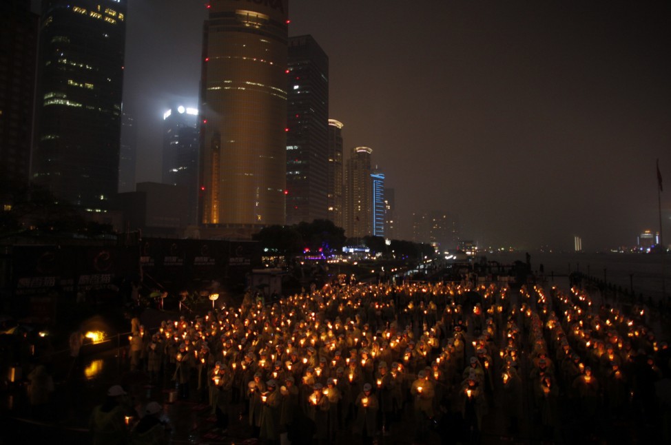 People hold candles during an event attempting to establish a Guinness World of Record for 'Blowing out the most number of candles simultaneously' during Earth Hour in Shanghai