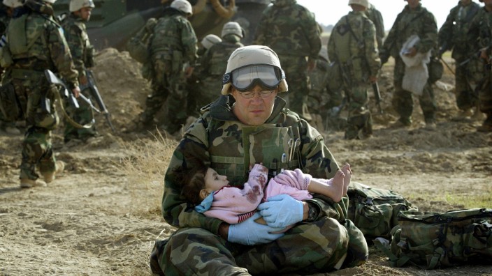 File photo of U.S. Marine holding an Iraqi child after crossfire ripped apart family in central Iraq