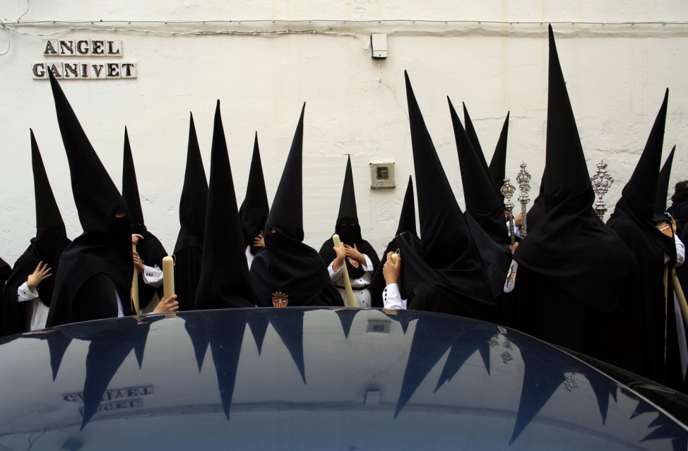 Penitents wait before taking part in the procession of 'Santa Genoveva' brotherhood during Holy Week in the Andalusian capital of Seville