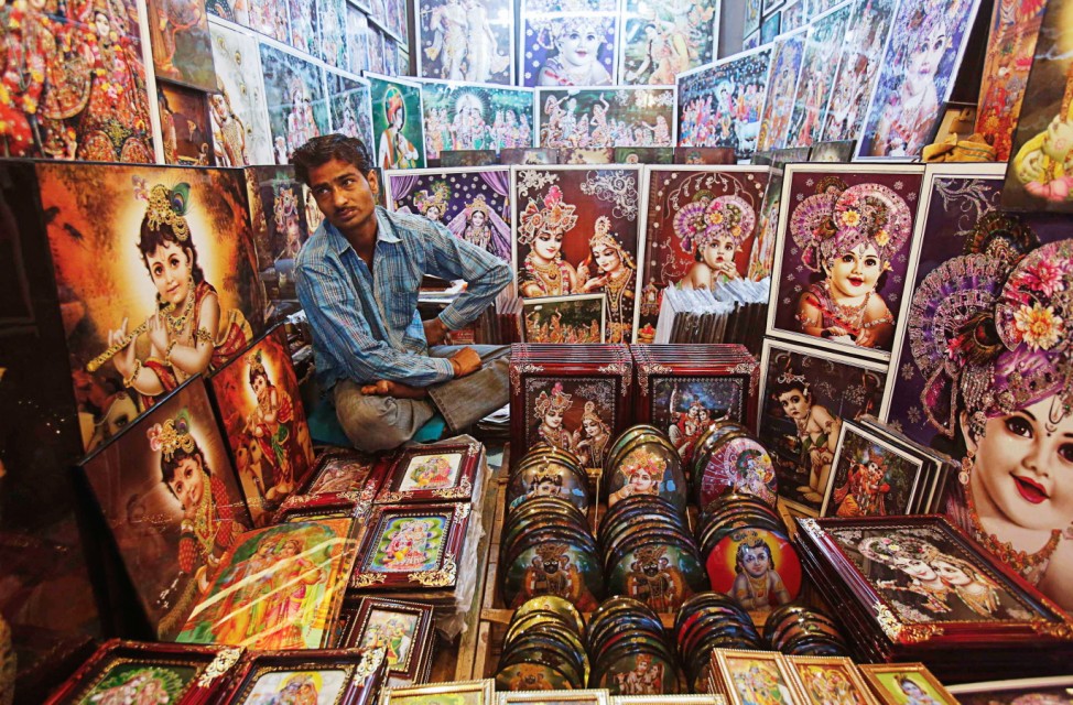 A vendor waits for devotees to buy portraits of the Hindu god Krishna and goddess Radha during holi celebrations near the Bankey Bihari temple in Vrindavan
