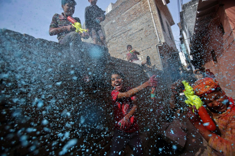 Boy sprays coloured foam during Holi celebrations in a lane near the Bankey Bihari temple in Vrindavan