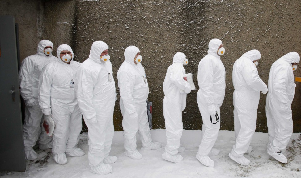 Workers wearing protective suits and masks exit fallout shelter during a nuclear accident simulation at Nuclear Power Plant Dukovany