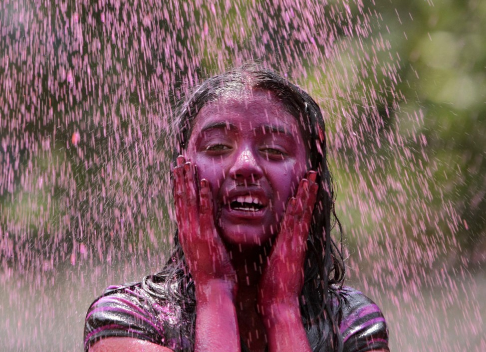 A girl is drenched with coloured water as part of Holi celebrations in the southern Indian city of Hyderabad