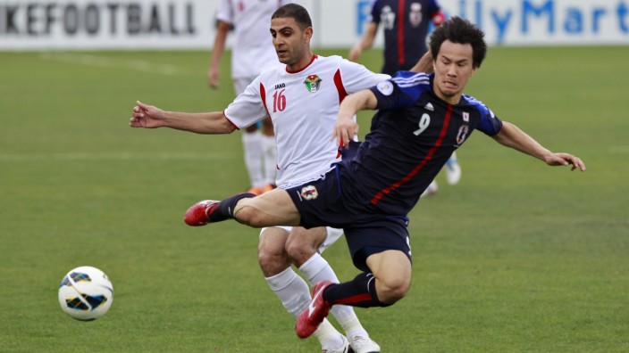 Japan's Okazaki fights for the ball against Jordan's Othman during their 2014 World Cup qualifying soccer match at King Abdullah stadium in Amman