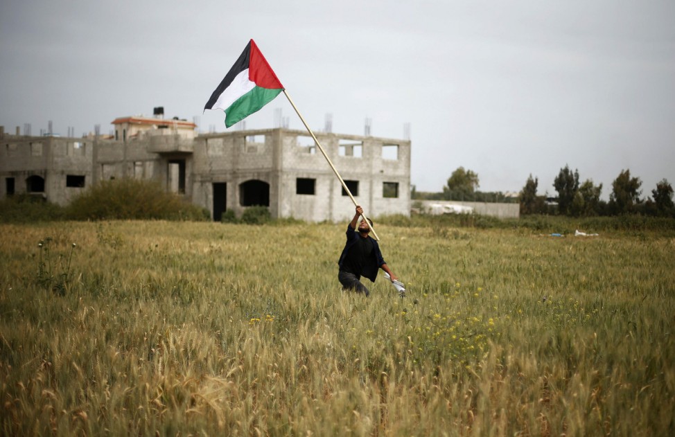 Protester holds a Palestinian flag during a protest marking Land Day in the northern Gaza Strip
