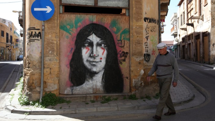 A man walks in front of a mural in central Nicosia