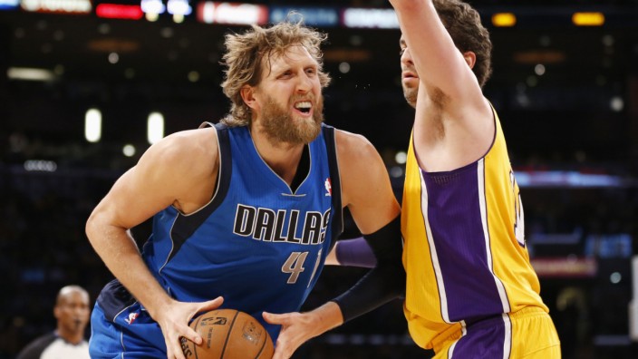 Dallas Mavericks' Dirk Nowitzki controls the ball as Los Angeles Lakers' Pau Gasol defends him during the first quarter of their NBA basketball game in Los Angeles