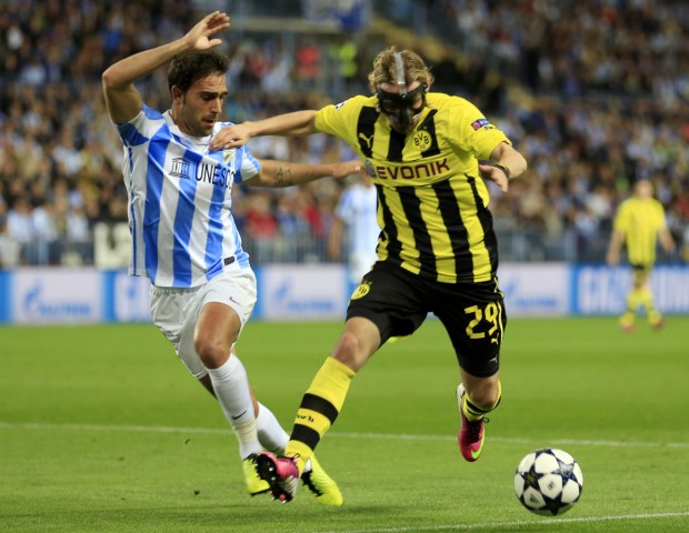 Malaga's Gamez is challenged by Borussia Dortmund's Schmelzer during their Champions League quarter final first leg soccer match at La Rosaleda stadium in Malaga