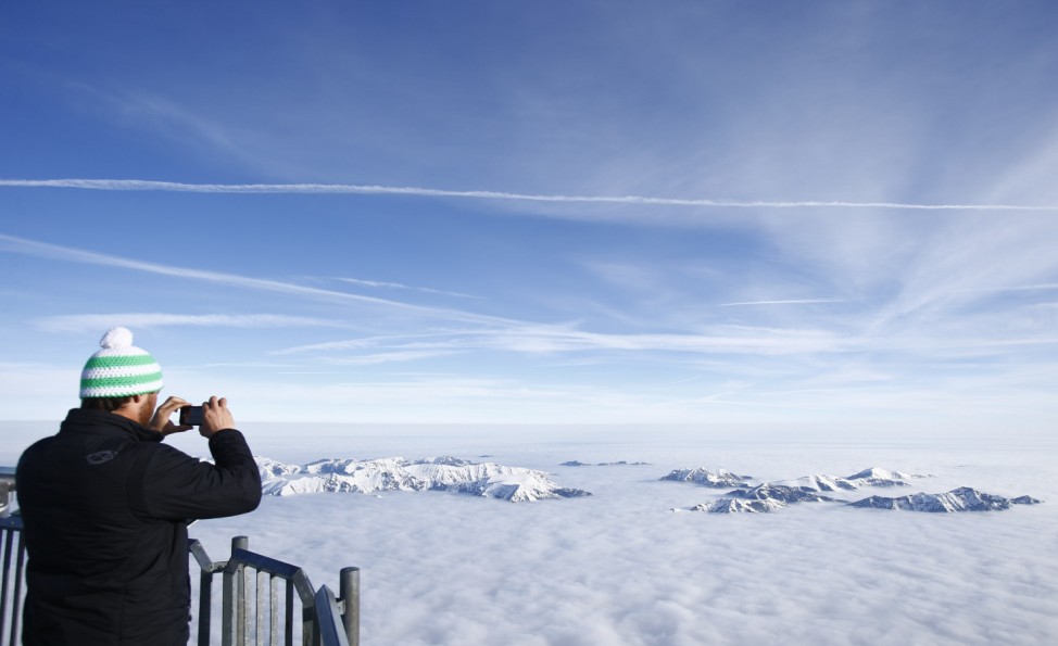Man takes pictures from Germany's highest mountain the Zugspitze in Grainau