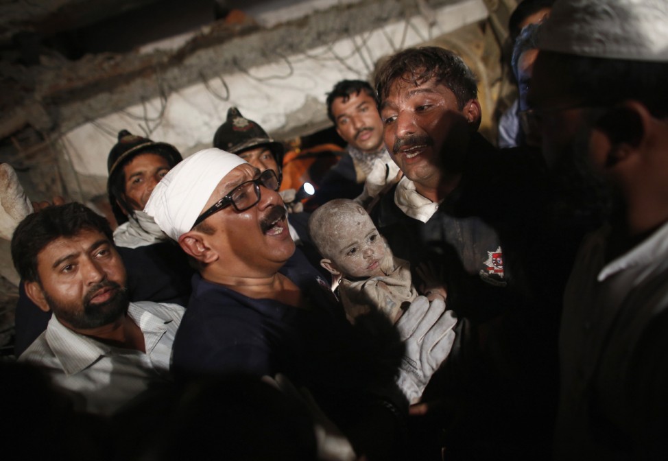 Rescue workers carry a child who survived from a collapsed residential building in Thane, on the outskirts of Mumbai