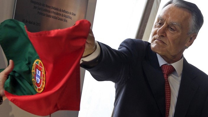 Portugal's President Anibal Cavaco Silva removes the Portuguese flag to unveil a plaque during the inauguration of GALP's new refinery plant in Sines