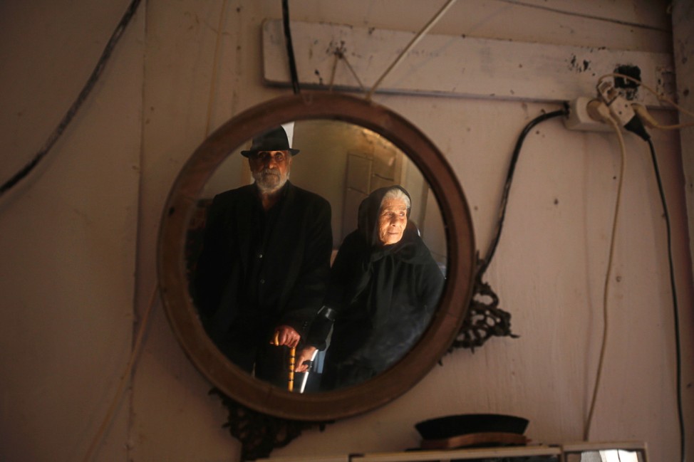 Isidoro, and wife Maria pose for portrait inside their shack at Terras do Lelo slum in Caparica