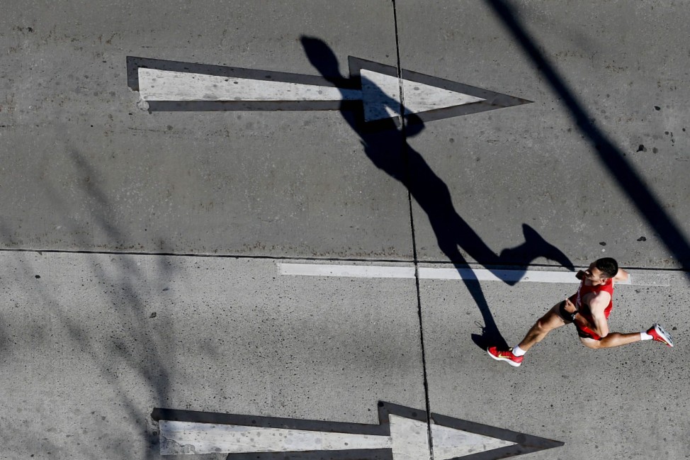 A runner casts a shadow as he takes part in the Vienna City Marathon in Vienna