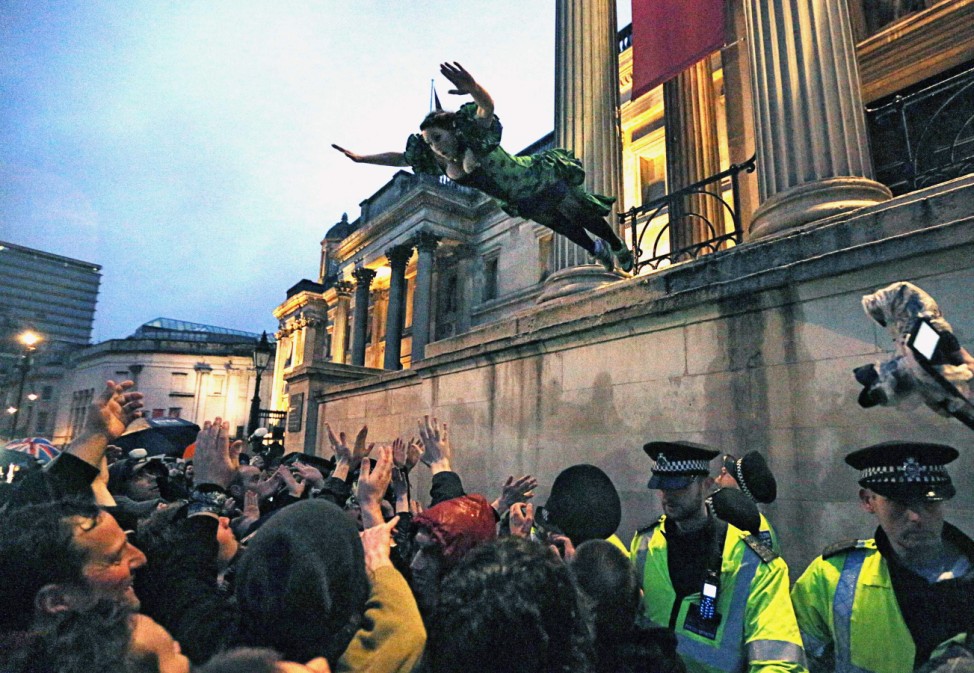 A reveller leaps into the crowd during an outdoor party celebrating the death of former British PM Thatcher in London