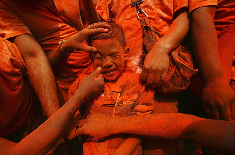 Boy is smeared with vermillion powder while celebrating 'Sindoor Jatra' vermillion powder festival at Thimi, near Kathmandu