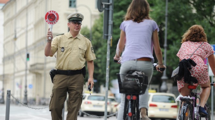 Polizist stoppt Fahrradfahrer in München.